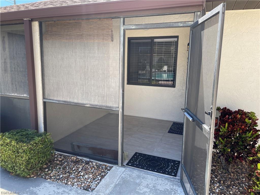 Screened patio enclosure with tiled flooring, a single window, and exterior landscaping