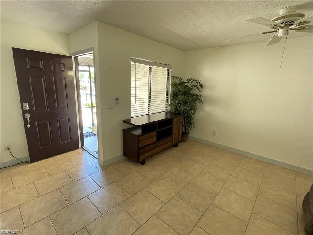 Tiled flooring throughout, ceiling fan, and window with horizontal blinds
