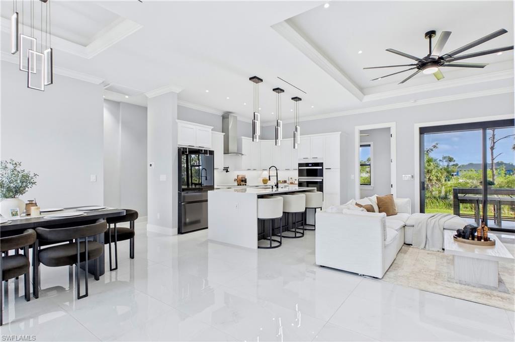Open-concept living space featuring high ceilings, recessed lighting, and large format tile flooring