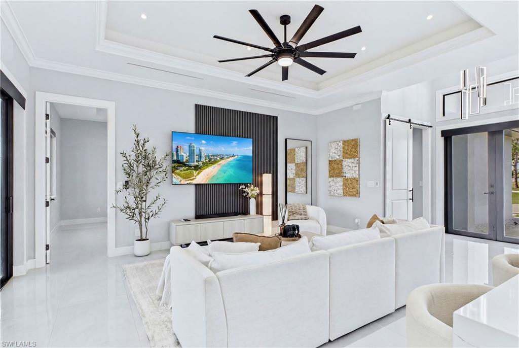 Recessed lighting, tray ceiling, and a multi-blade ceiling fan