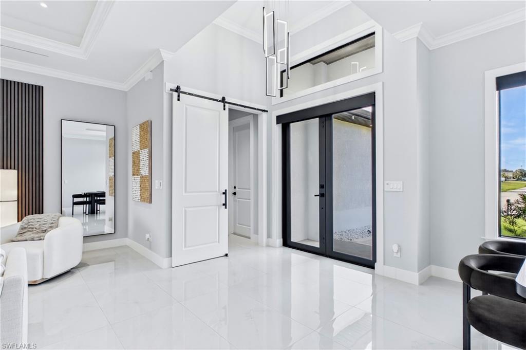 Vaulted ceilings, white tile flooring, contemporary pendant lighting, and a barn-style door