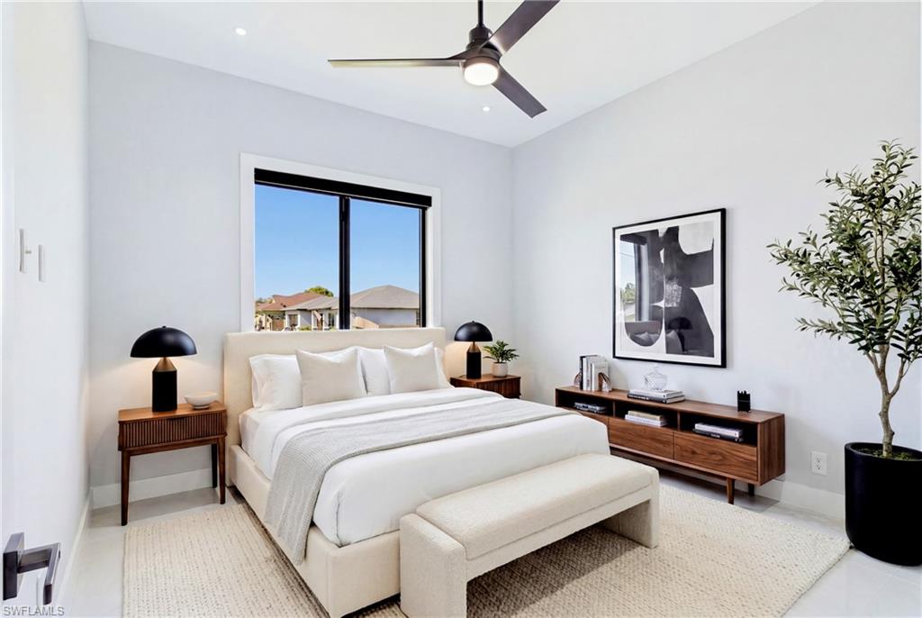 Recessed ceiling lighting, ceiling fan, large window with black trim, and light-toned flooring