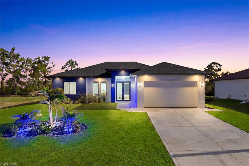 Modern single-story residence featuring a dark shingle roof and a light-toned exterior with blue accents