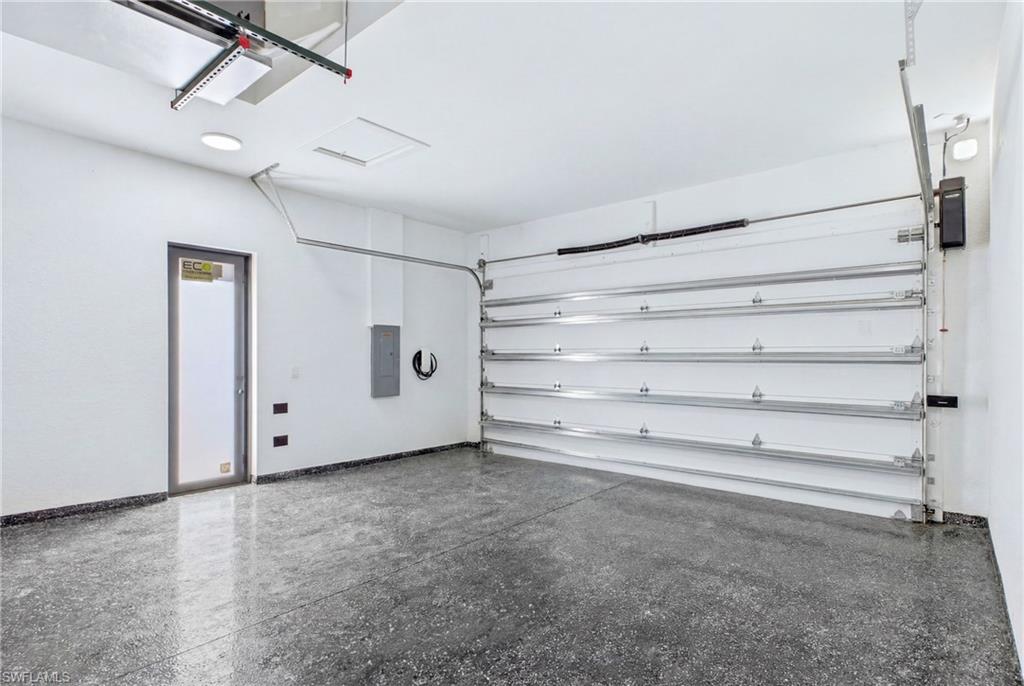 Polished concrete flooring, contemporary overhead lighting, and an automatic garage door system