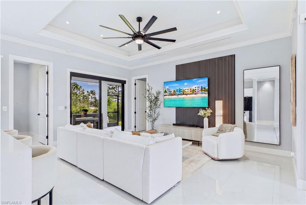 Recessed lighting, tray ceiling, and a multi-blade ceiling fan