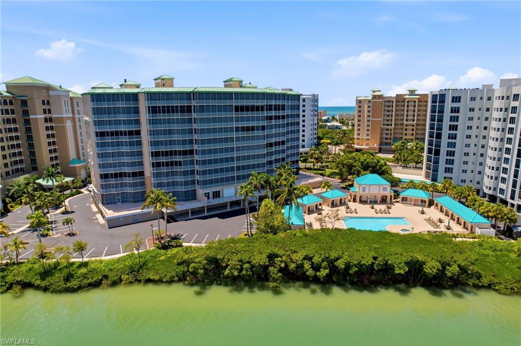 An expansive resort-style community pool overlooks the shimmering waters of Estero Bay, offering a spectacular setting for relaxation and enjoying the breathtaking coastal views.