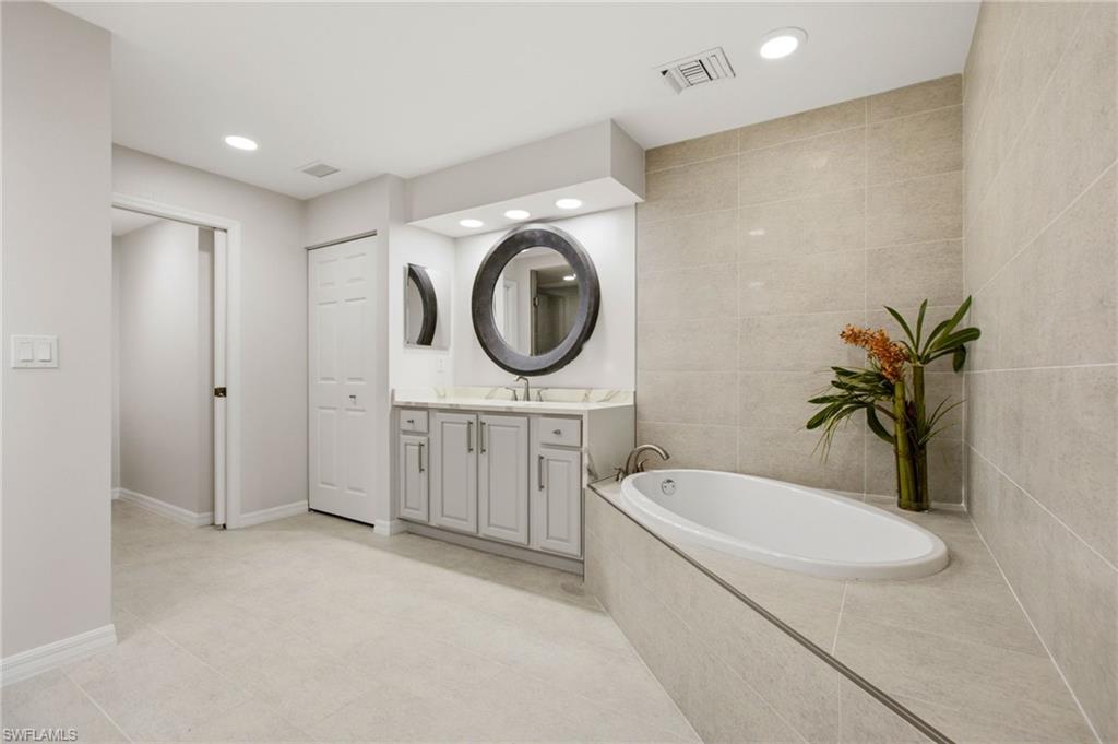 Its luxurious ensuite bath showcases floor-to-ceiling porcelain tile in the walk-in shower, seamless glass enclosure, separate soaking tub, quartz-topped vanity and private water closet.