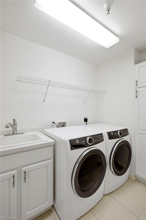 A generously sized laundry room offers exceptional functionality with front-loading washer and dryer, abundant storage, a convenient closet, and a deep utility sink.