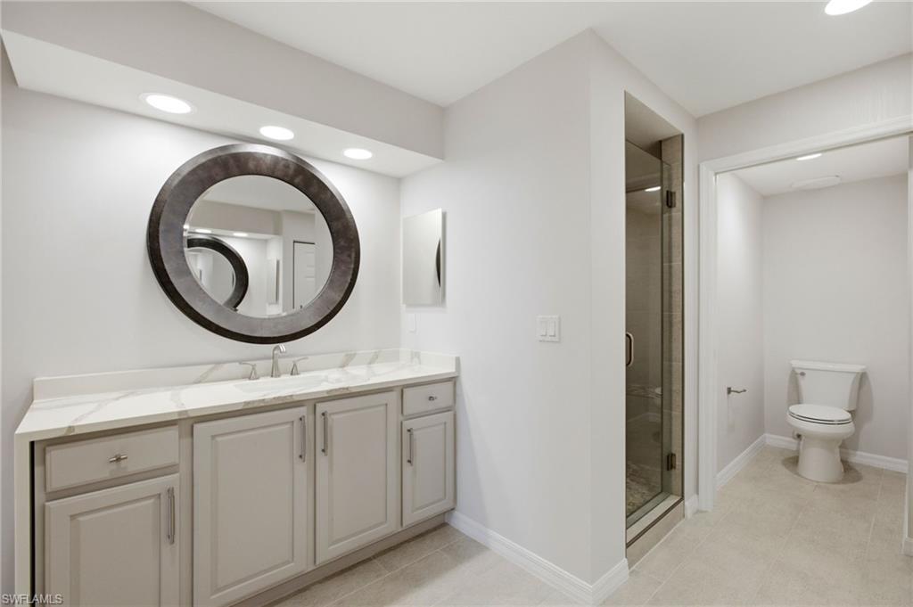 A stunning waterfall quartz countertop elevates the spectacularly remodeled ensuite bathroom, creating a refined, spa-inspired ambiance with exceptional style and sophistication.