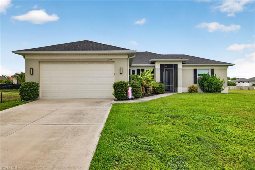 Contemporary stucco exterior with a hip roof, attached garage, and screened entry