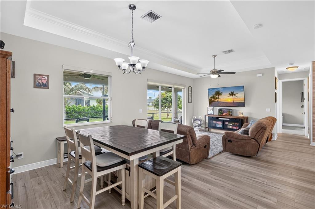 Tray ceiling, wood-finish flooring, recessed lighting, ceiling fan, and sliding glass door