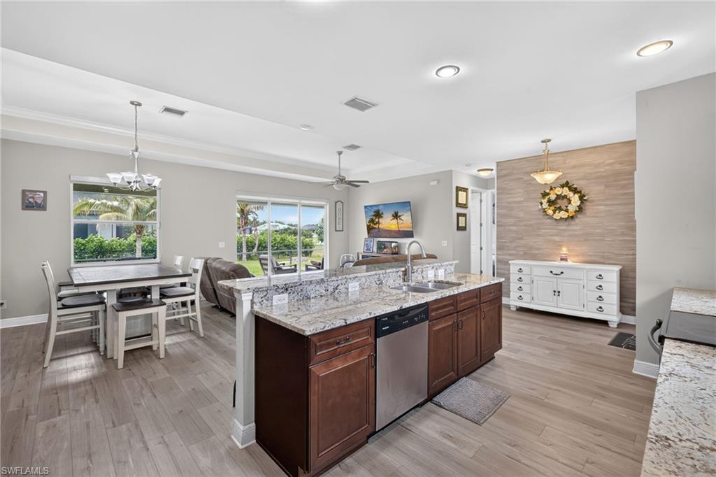 Kitchen island with granite countertop, integrated stainless steel sink, and dishwasher