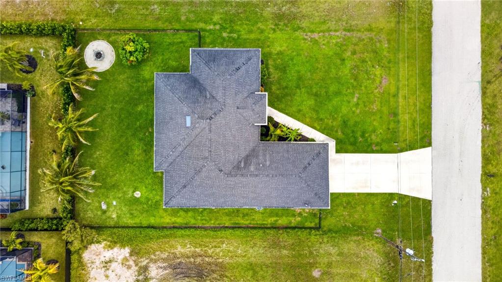 Gabled roofline, concrete driveway, and surrounding green space