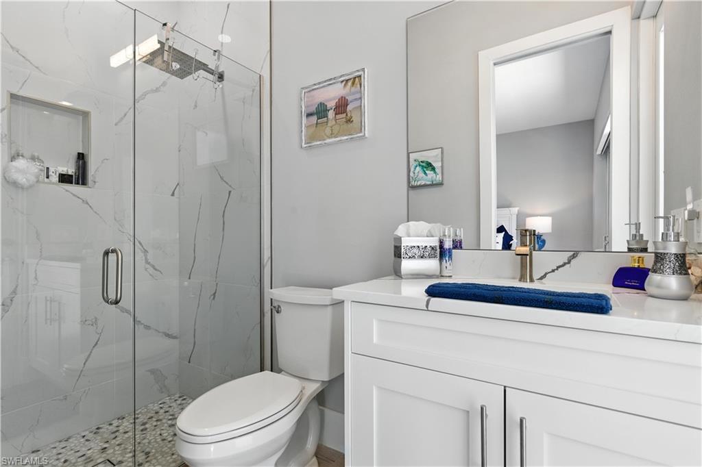 Full bathroom featuring a marble finish shower and vanity