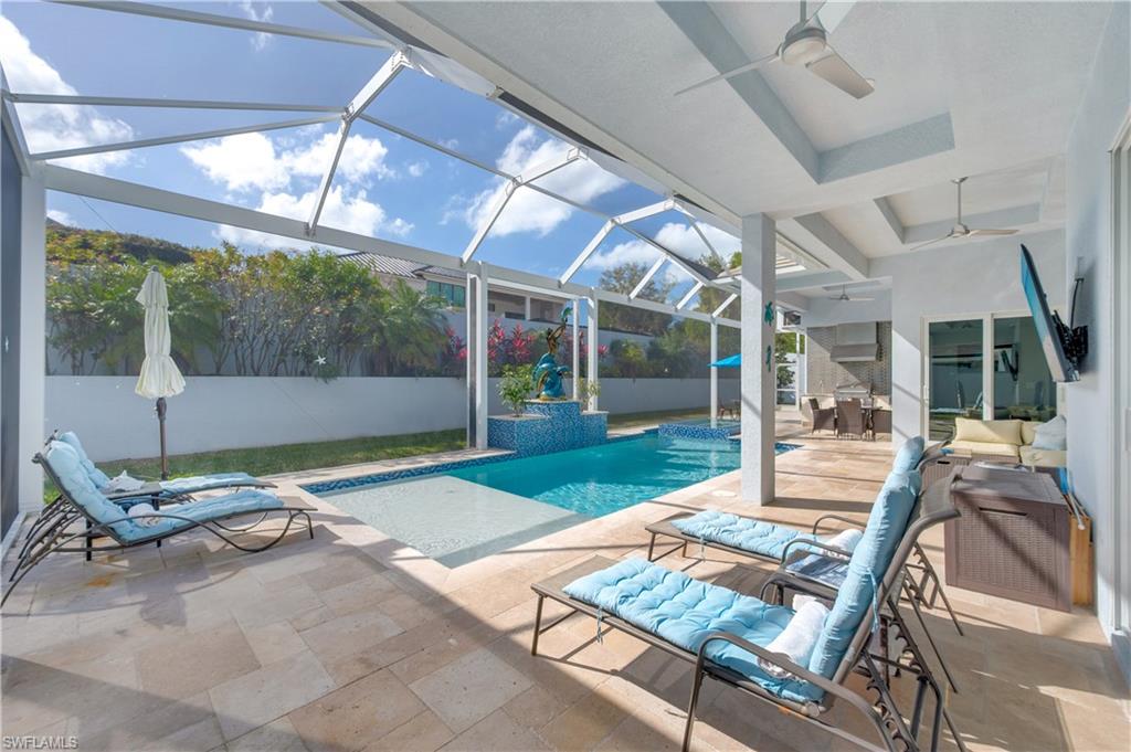Swimming pool featuring glass enclosure, a patio, and a sunroom