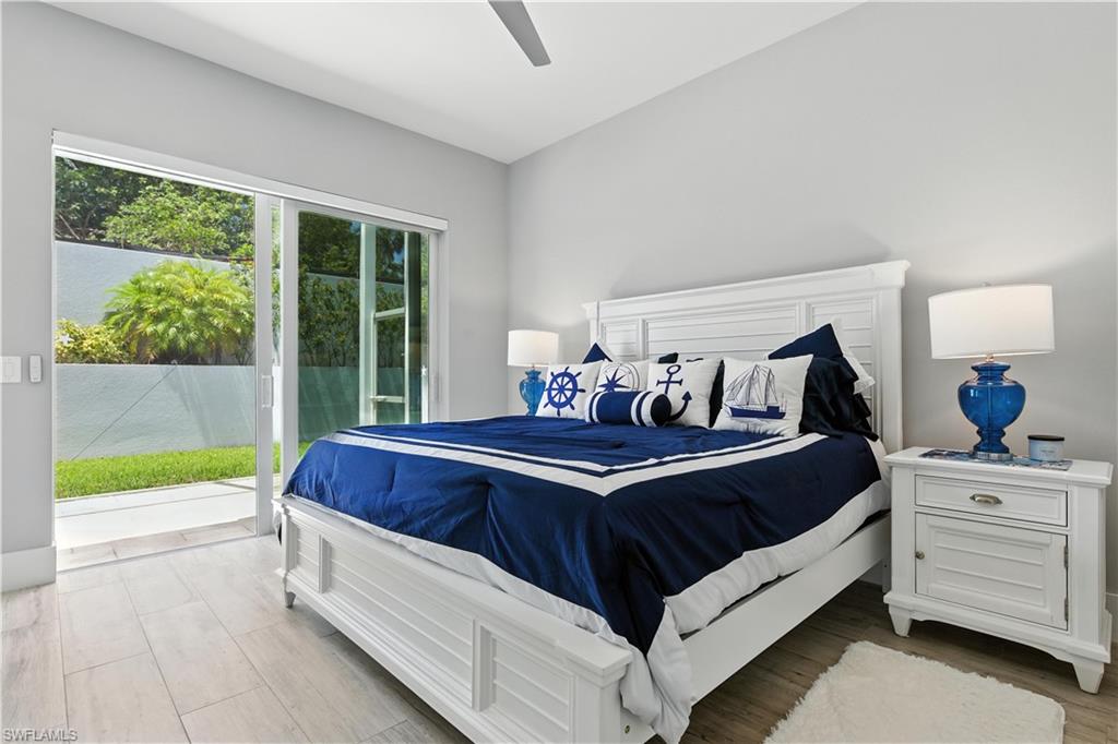 Bedroom with access to outside, wood finished floors, and a ceiling fan