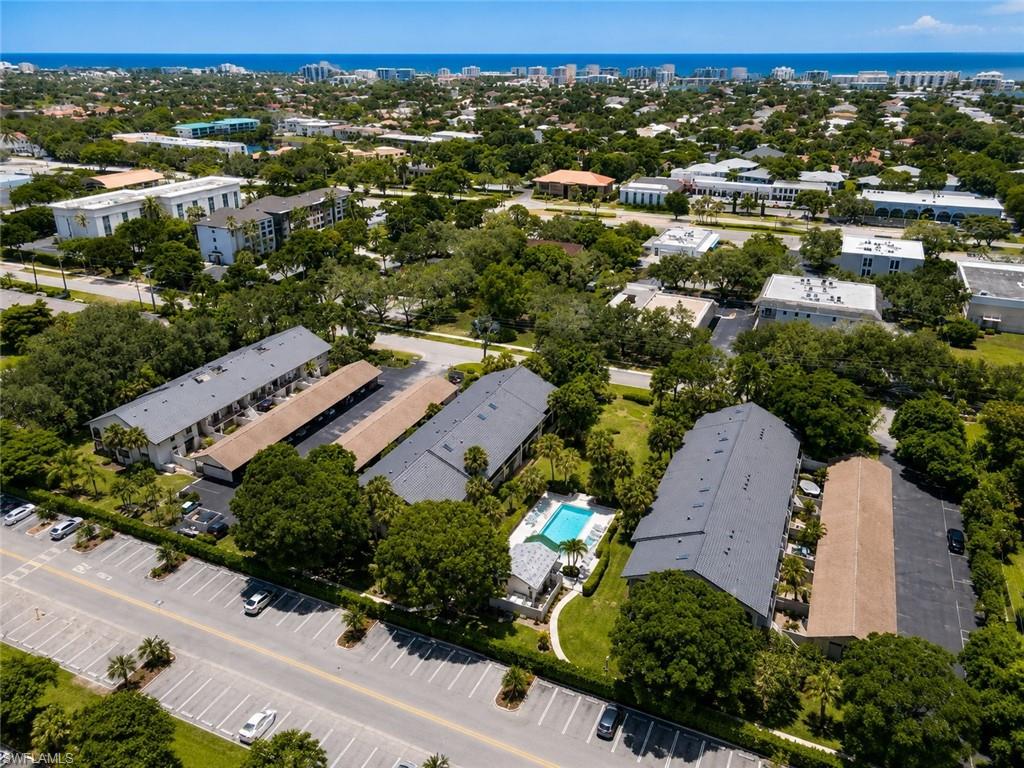 Aerial perspective featuring multiple structures, a swimming pool, and dedicated parking areas