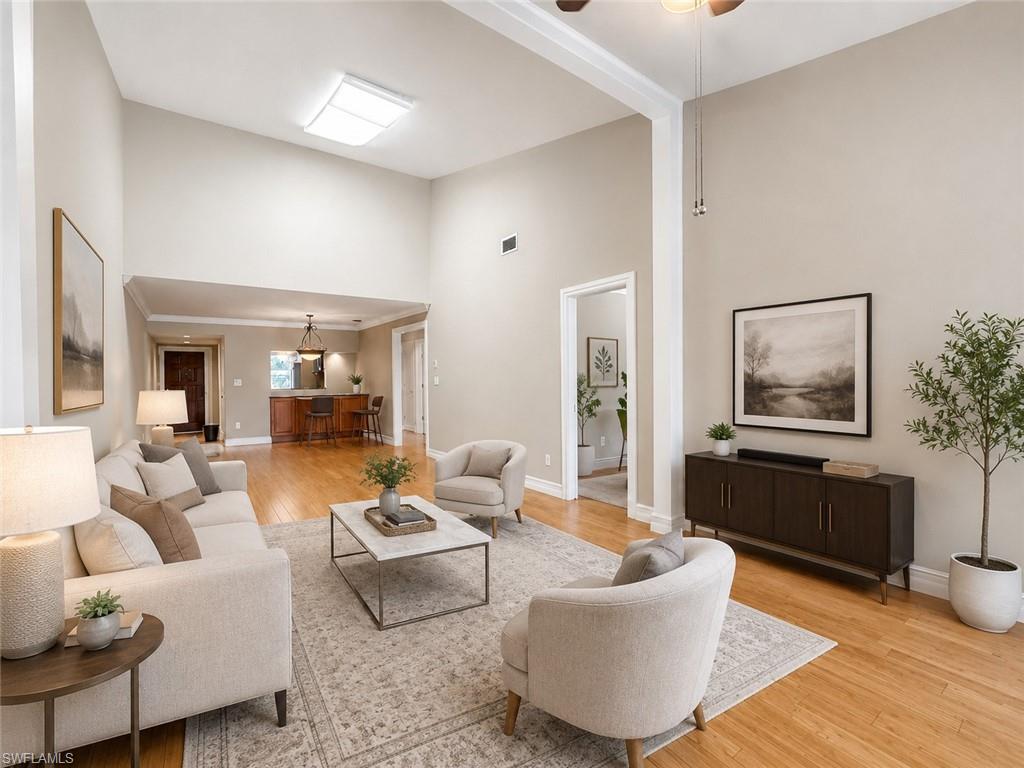 Vaulted ceiling, recessed lighting, wood-finish flooring, light-toned walls, and white trim