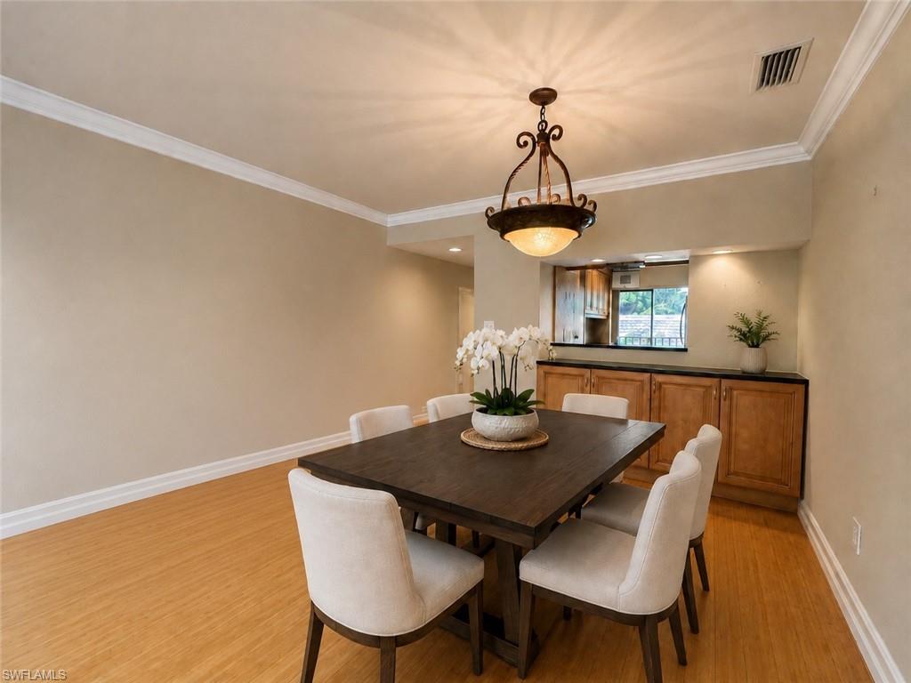 Wood-finish flooring, crown molding, and a ceiling fan with integrated lighting
