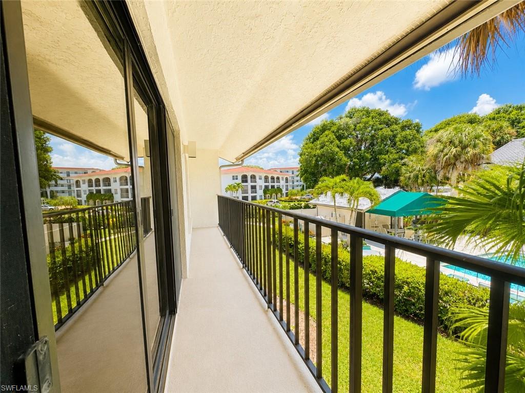 Private balcony with a concrete floor, dark metal railing, and sliding glass doors