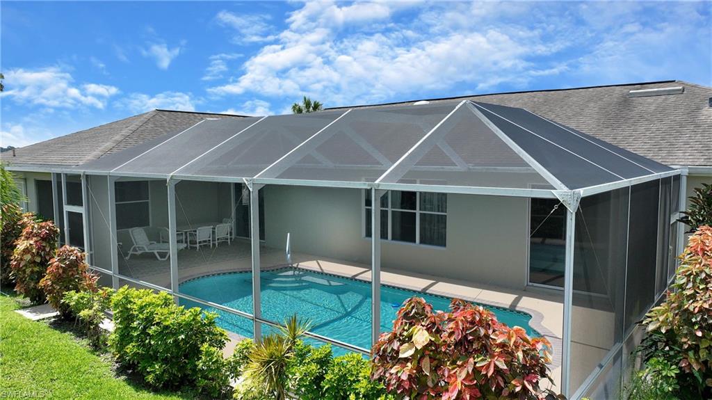 Screened enclosure with an in-ground swimming pool and a light-colored patio deck