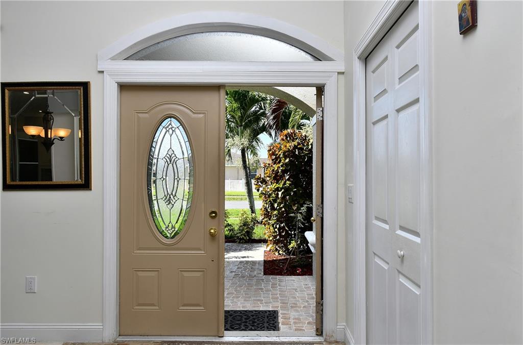 Entry door featuring an oval leaded glass insert and an arched transom window