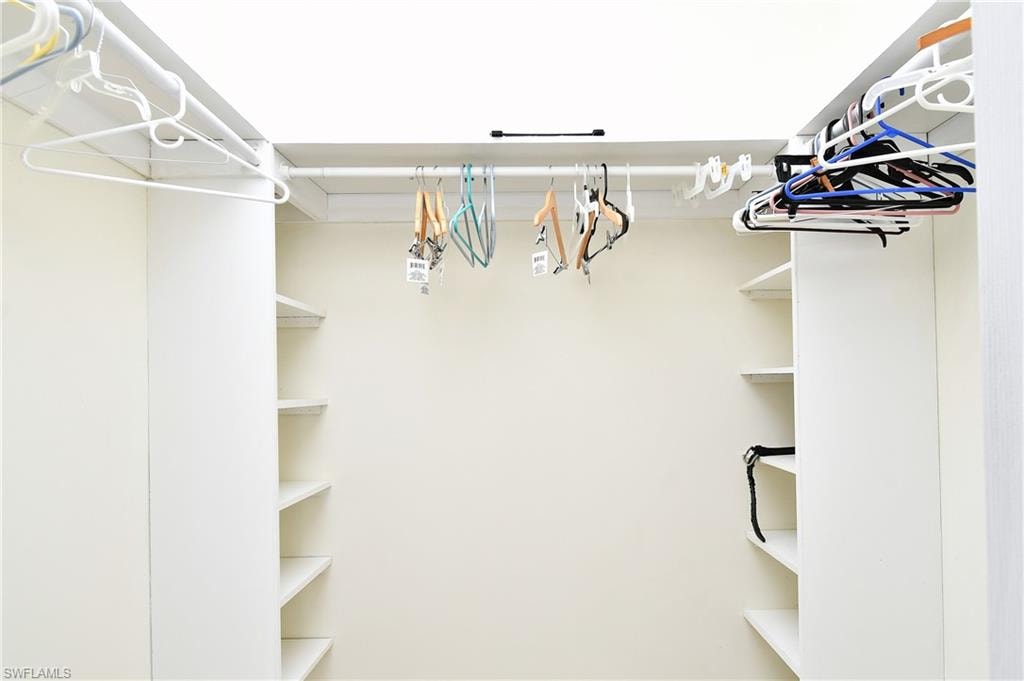 Built-in white shelving and hanging rods provide organizational options