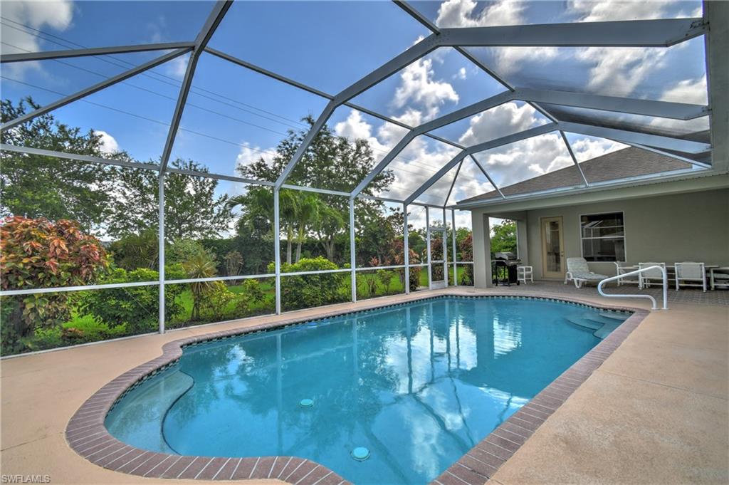 Screen-enclosed swimming pool with a curved design and integrated steps