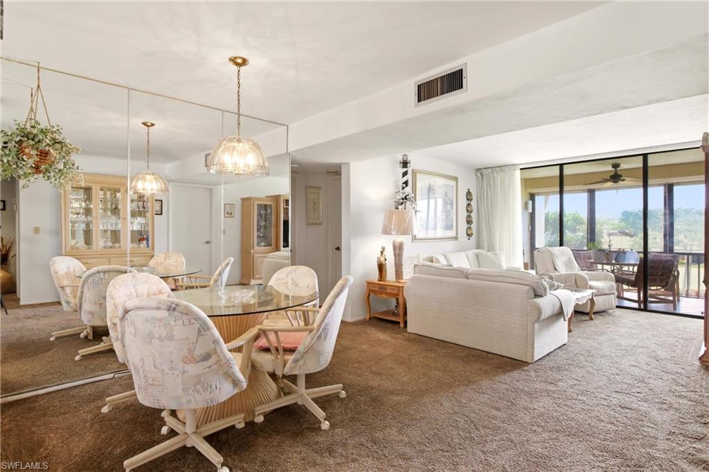 Open concept living and dining area with expansive mirrored wall and an attached outdoor balcony