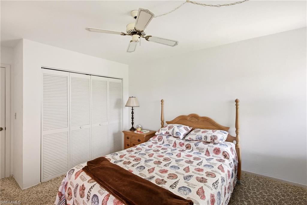 Bedroom featuring white walls and textured carpeting