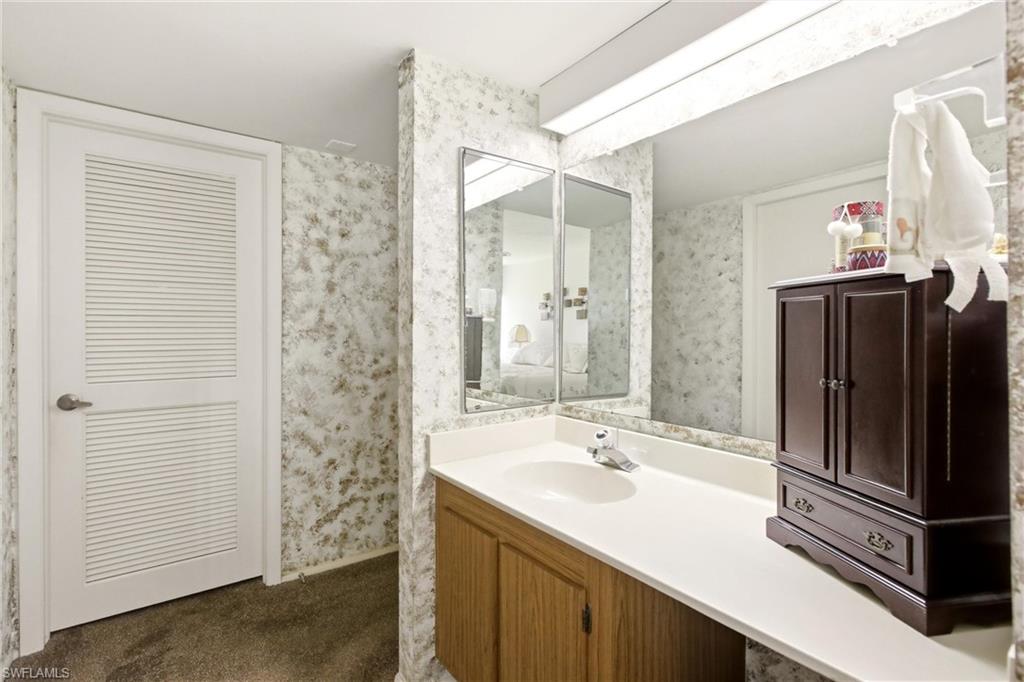 Vanity featuring a single basin, laminate countertop, and wood-finish cabinetry