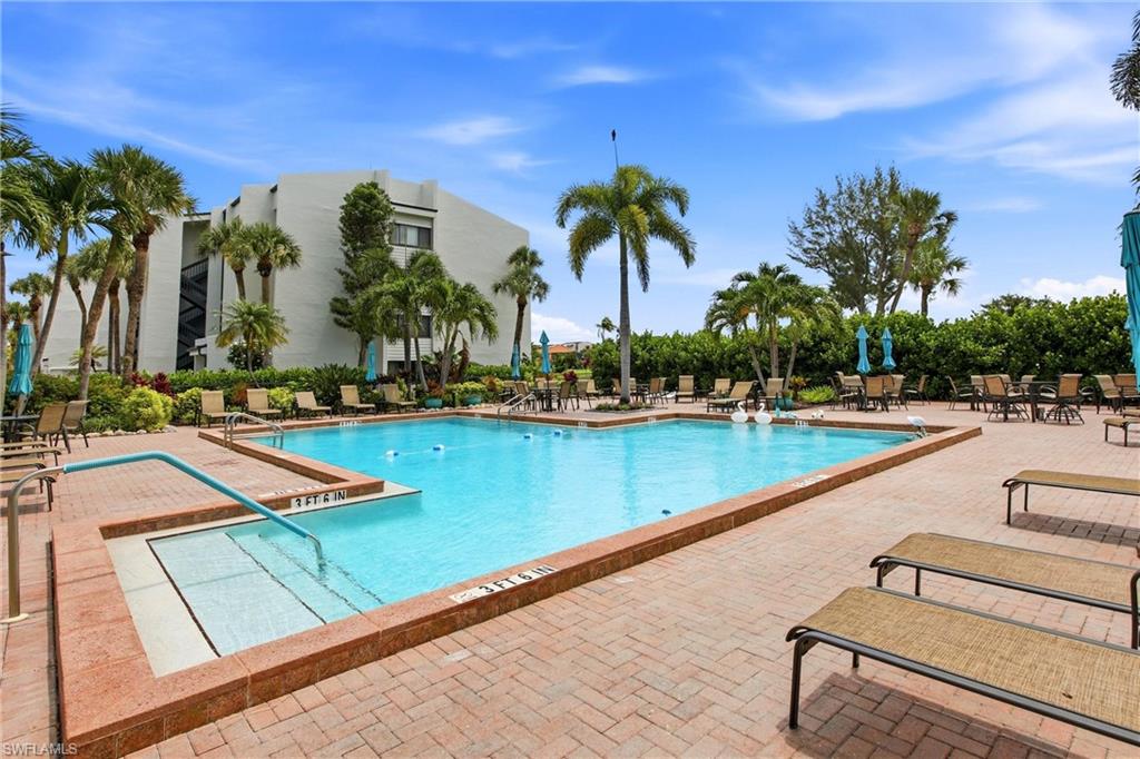 Spacious outdoor pool area featuring a rectangular pool with integrated steps, surrounded by a brick paver deck
