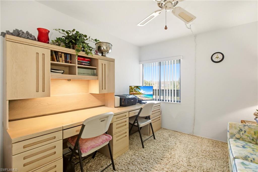 Built-in desk unit featuring wood-finish cabinetry, integrated shelving, and task lighting