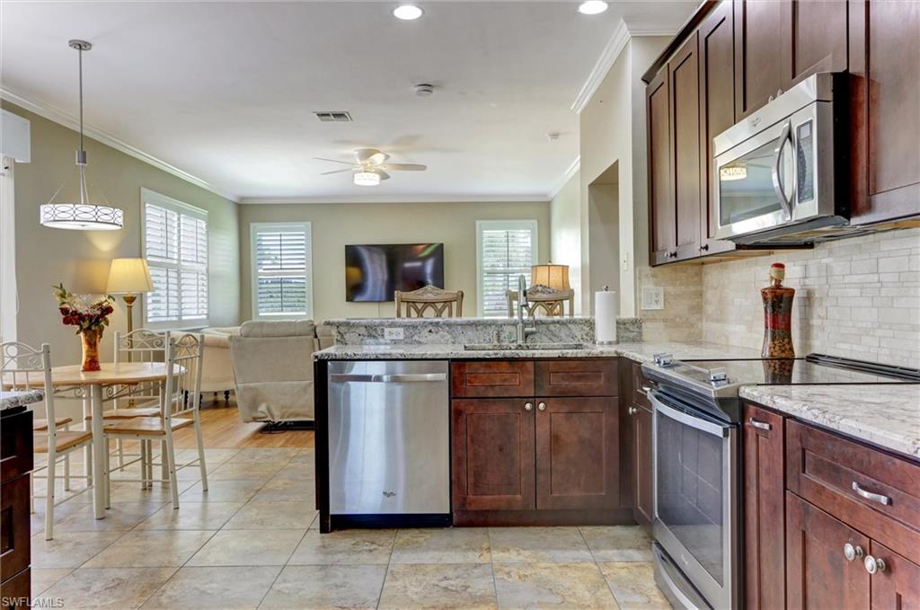 Kitchen featuring stainless steel appliances, stone countertops, and wood-finish cabinetry