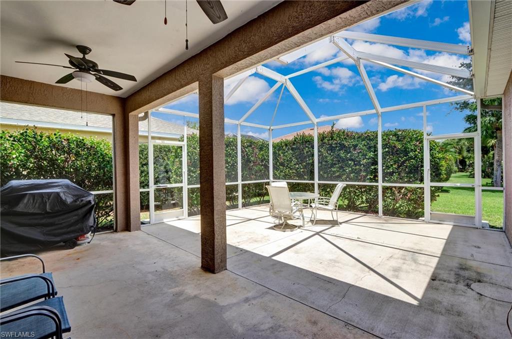 Screened patio with concrete flooring, vaulted screen enclosure, and a ceiling fan