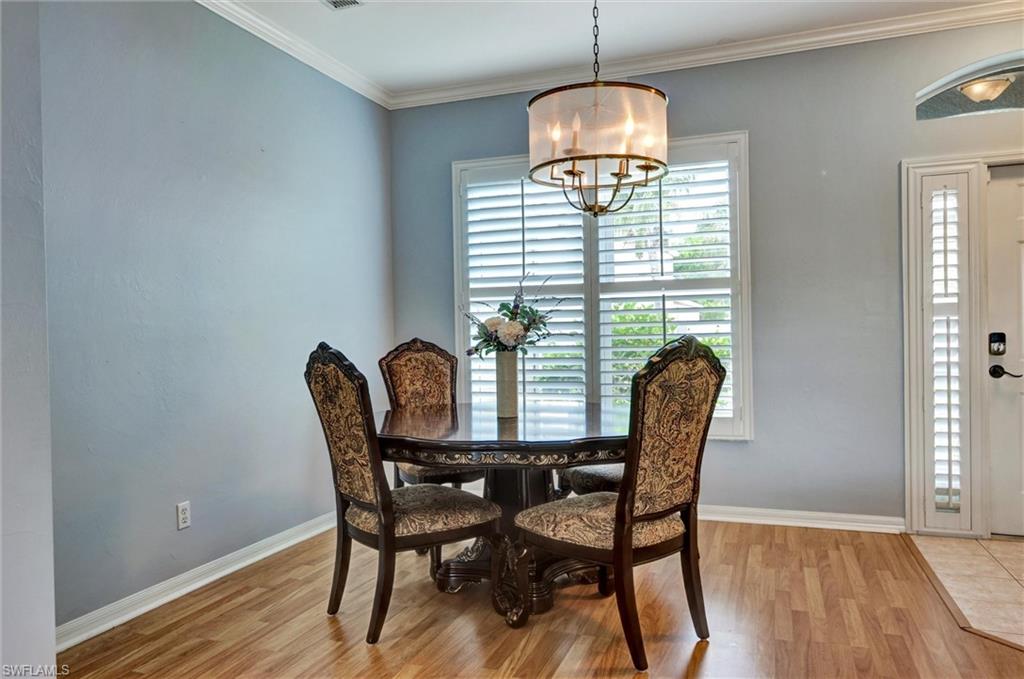 Wood-finish flooring, crown molding, and a drum-style chandelier