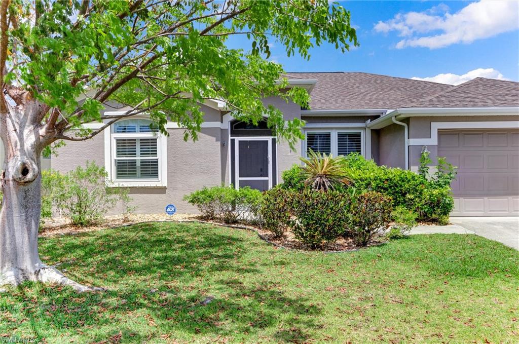 Stucco exterior with a shingled roof, arched window, and attached garage