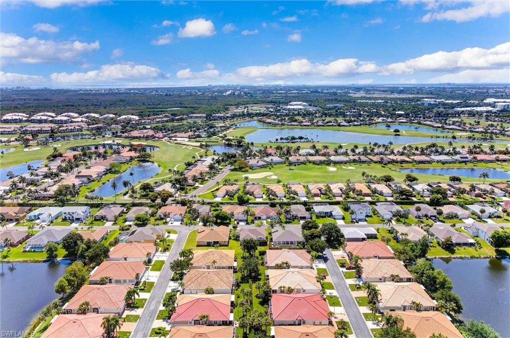 Lush green golf course, multiple residential properties, extensive water features, paved roadways, and mature landscaping