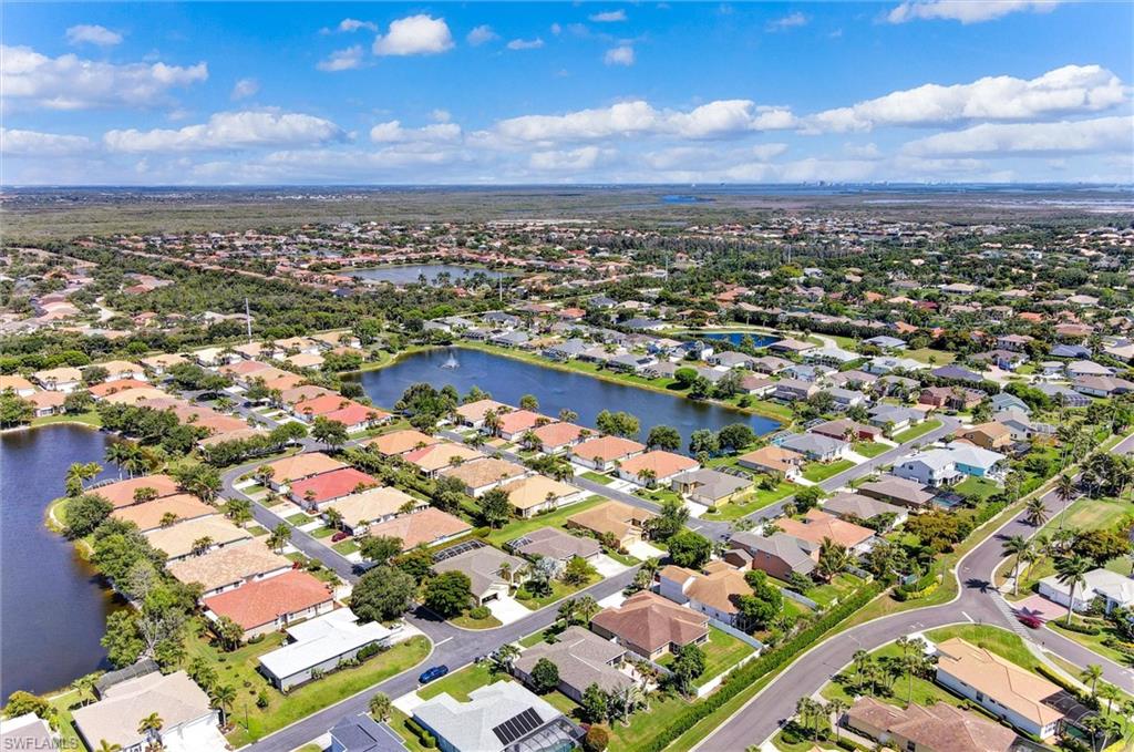 Expansive neighborhood featuring numerous residential properties, abundant mature landscaping, and multiple water features