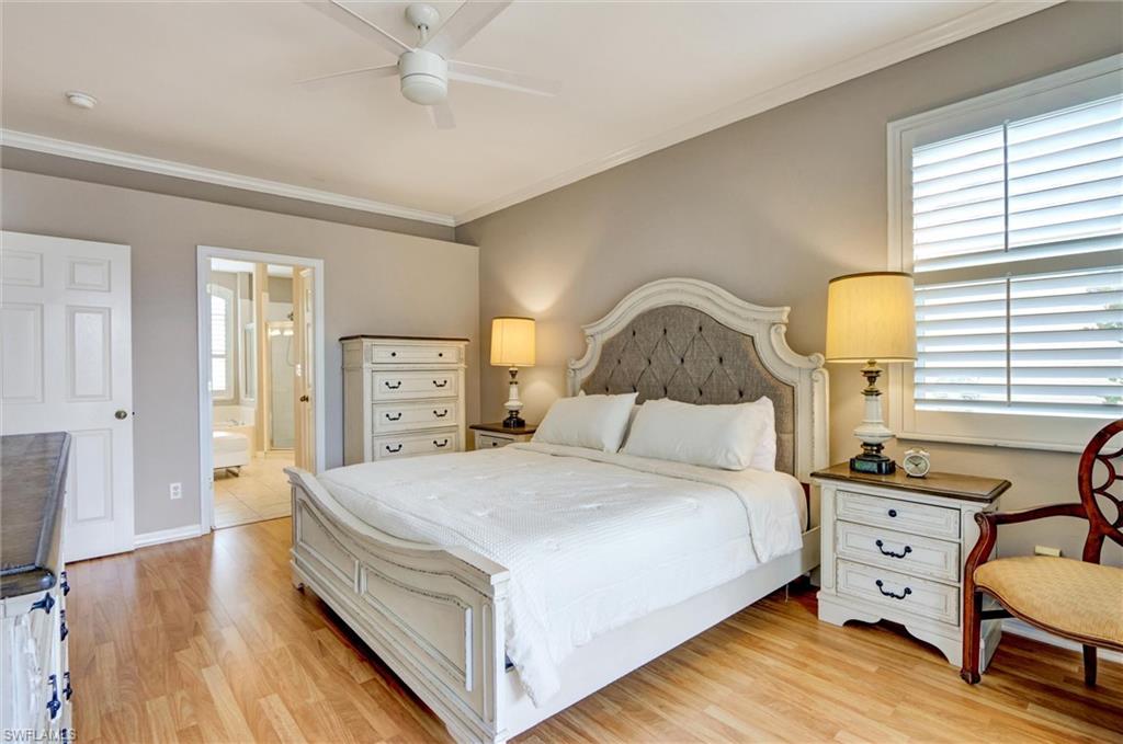 Wood-finish flooring, crown molding, ceiling fan, and white window shutters