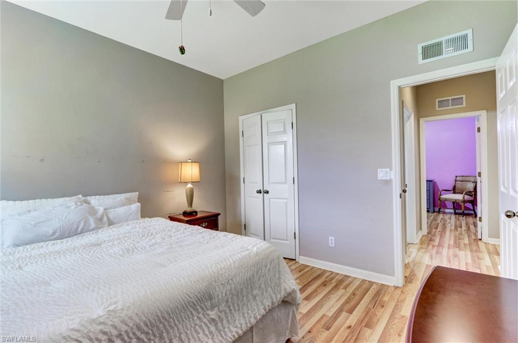 Wood-finish flooring throughout, white bi-fold closet doors, and a ceiling fan with light fixture