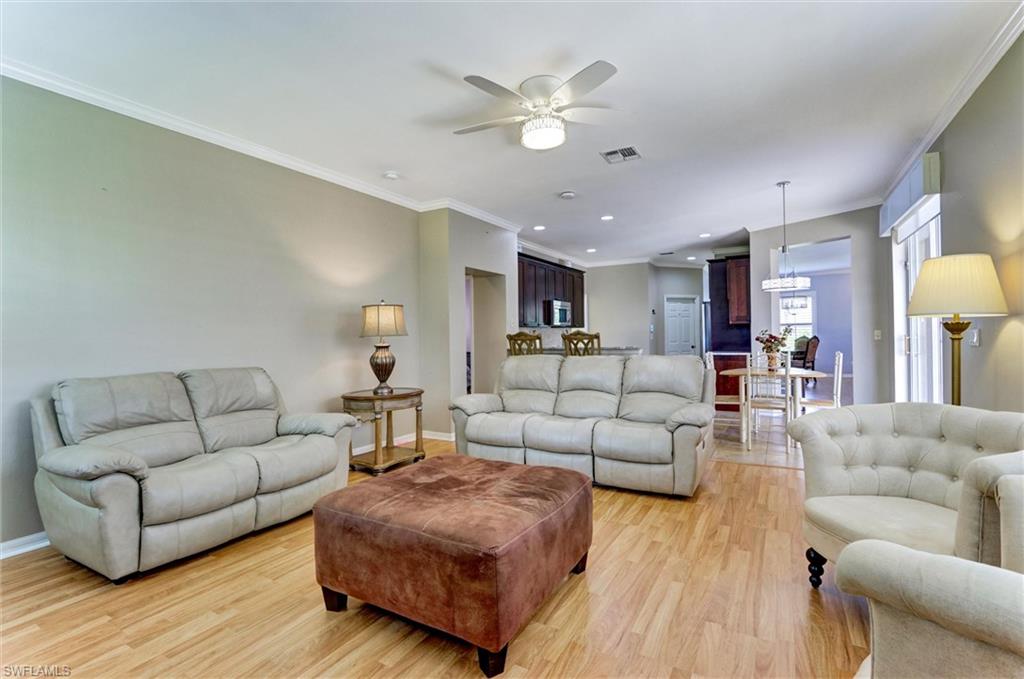 Wood-finish flooring throughout, crown molding, and a ceiling fan with integrated lighting