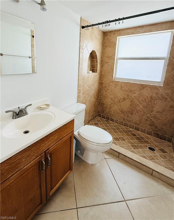 Tiled shower with an arched niche and a window