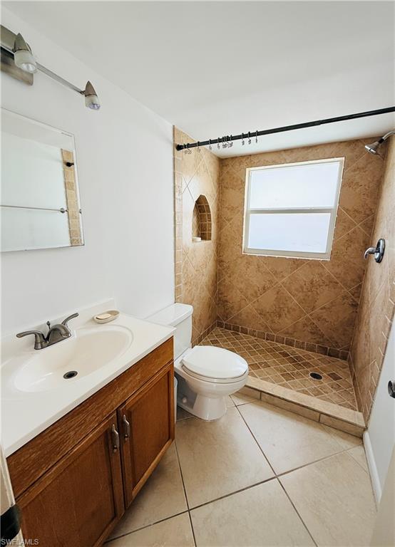 Walk-in shower with tiled walls and floor, featuring an arched recess