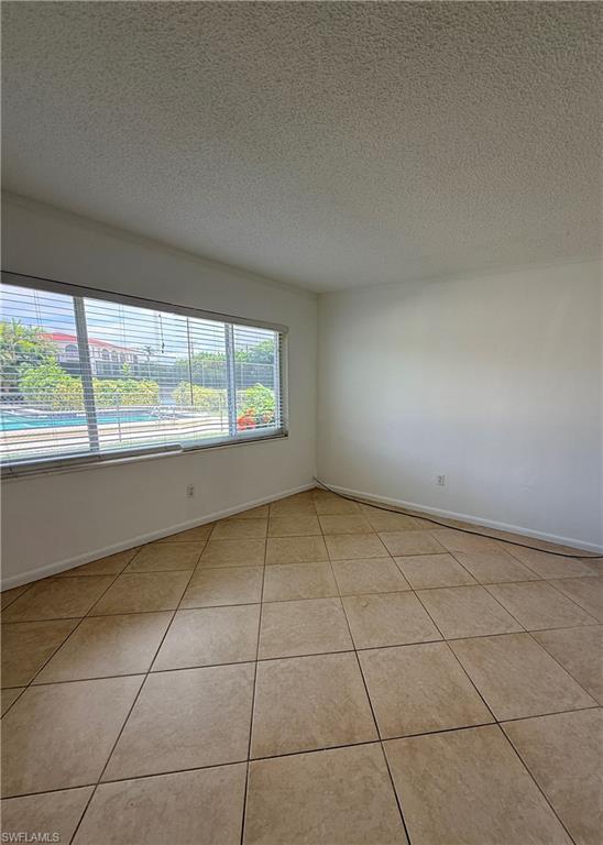 Tiled flooring with large format square tiles, white walls, and horizontal window blinds