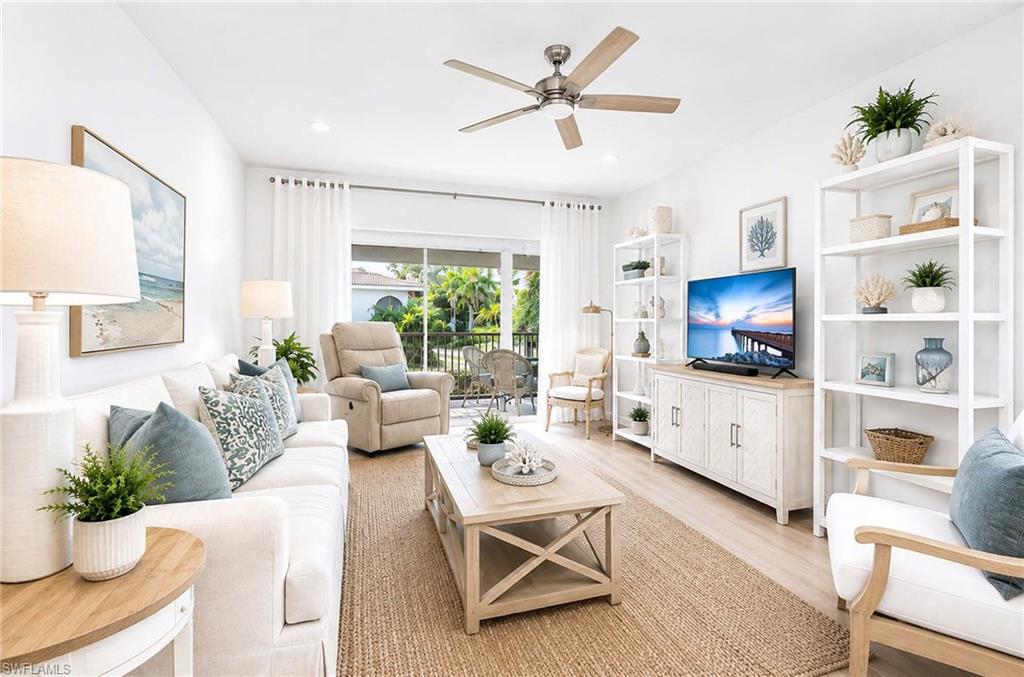 Virtual Renovation: Open-concept living space with light-toned wood-finish flooring, a ceiling fan, and sliding glass doors to an outdoor area