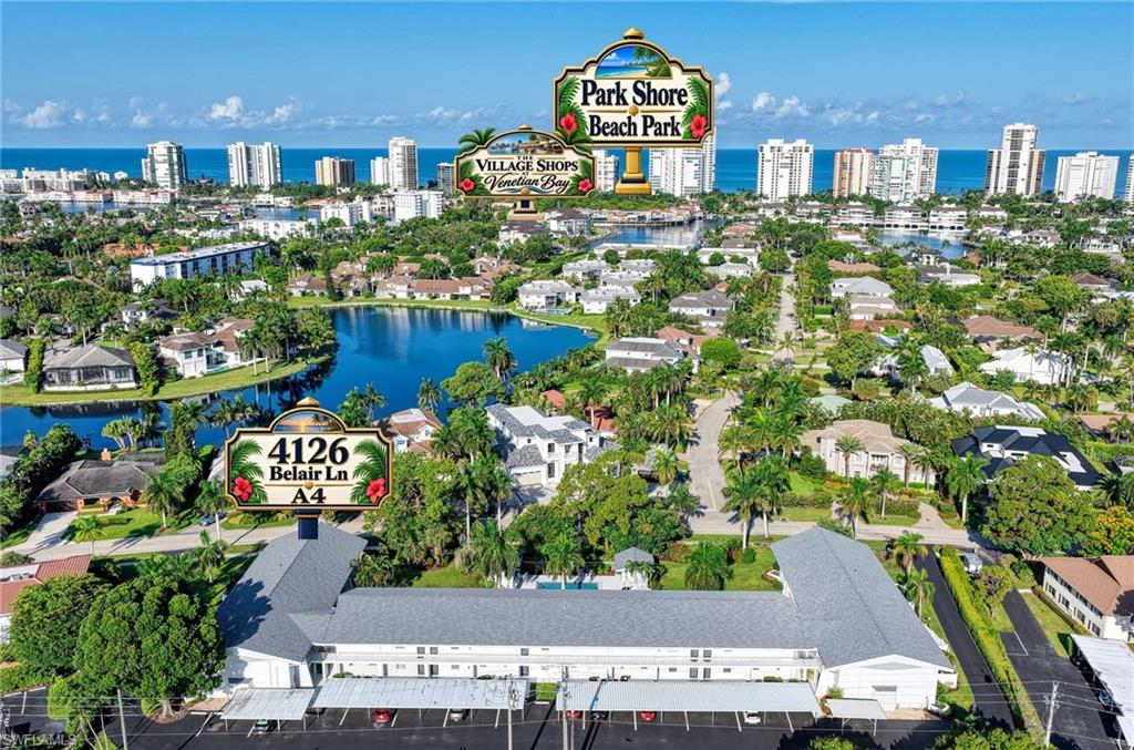 Coastal area with residential properties, lush green landscaping, and a substantial body of water