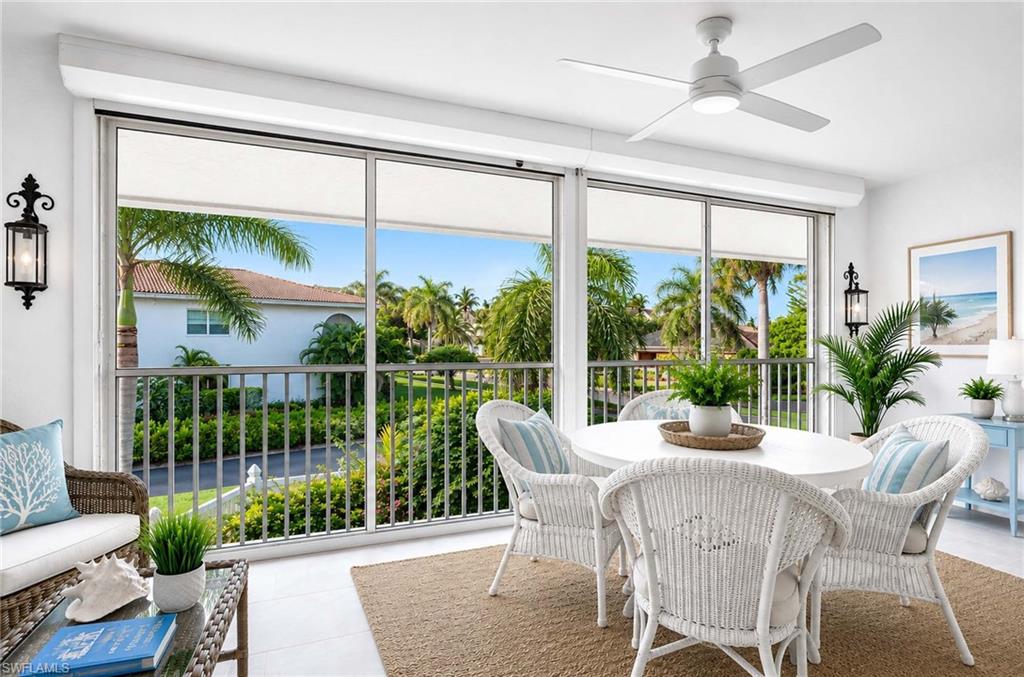 Virtual Staging: Expansive full-height windows, a ceiling fan with integrated lighting, two wall-mounted lanterns, and a balcony with metal railings