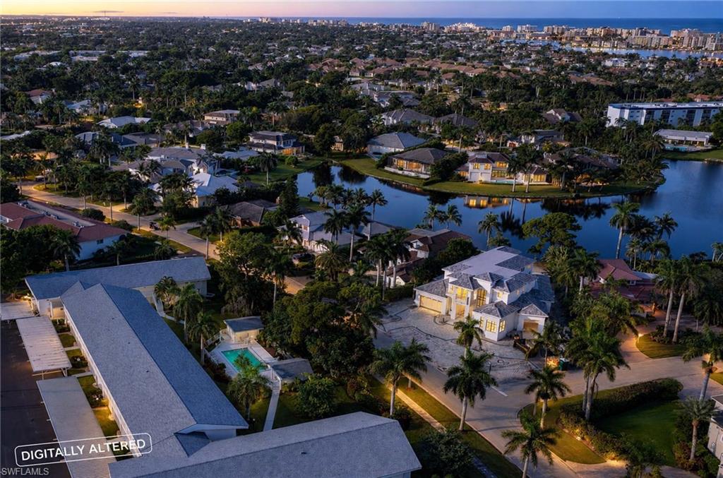 Aerial twilight perspective showcasing an expansive waterfront estate nestled within a lush tropical landscape