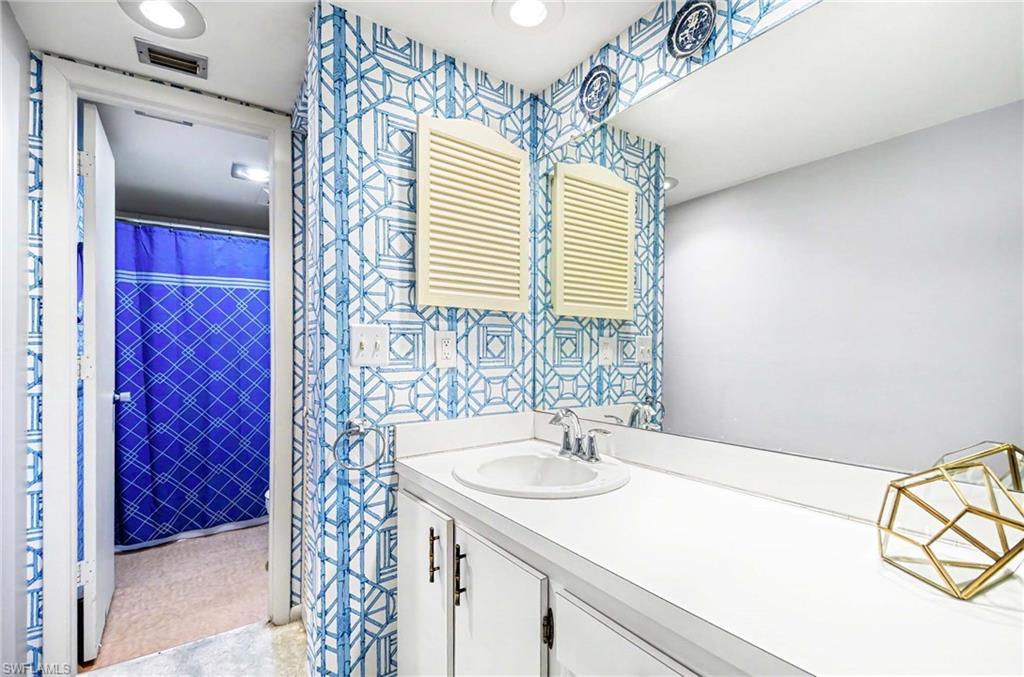 Vanity with an integrated sink, polished chrome faucet, and expansive mirror